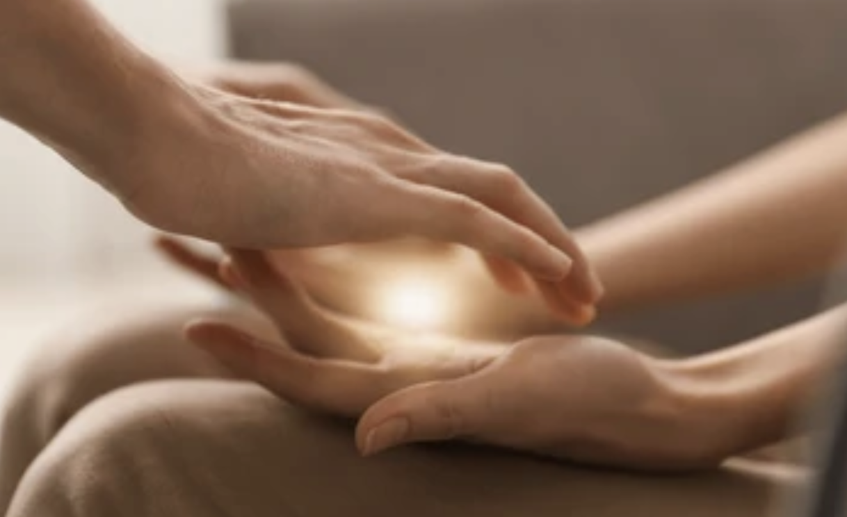 Energy healing session with hands above the body in a serene setting
